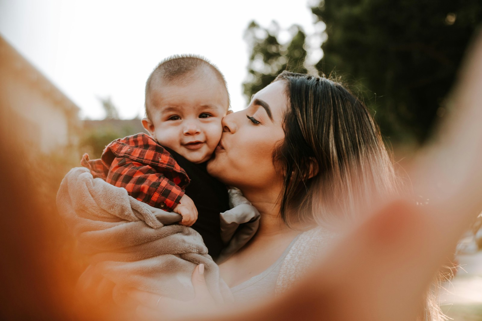woman kiss a baby while taking picture, life